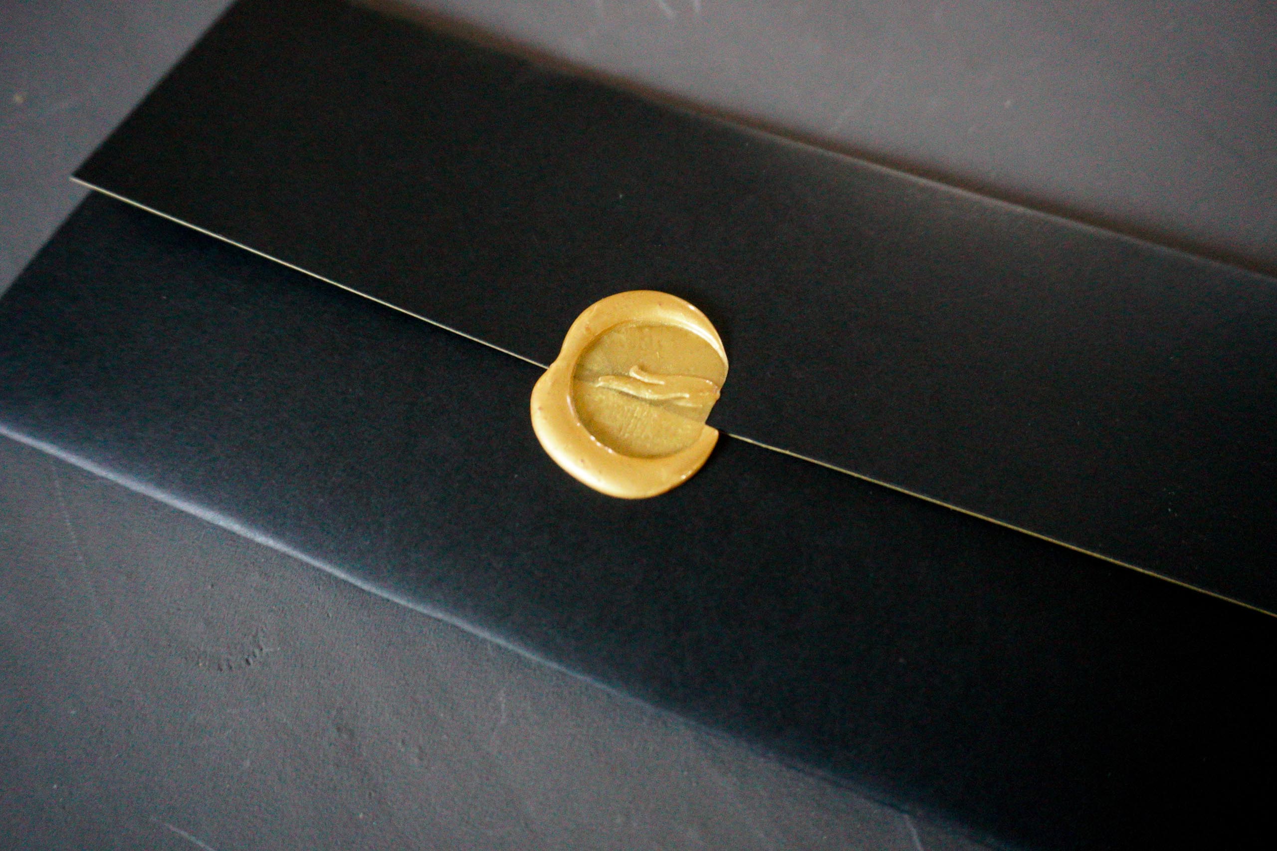 and a gold wax-seal of their logo